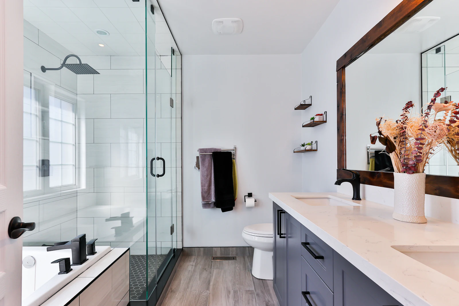 Family bathroom with a glass shower enclosure, double vanity in slate blue and matt black taps